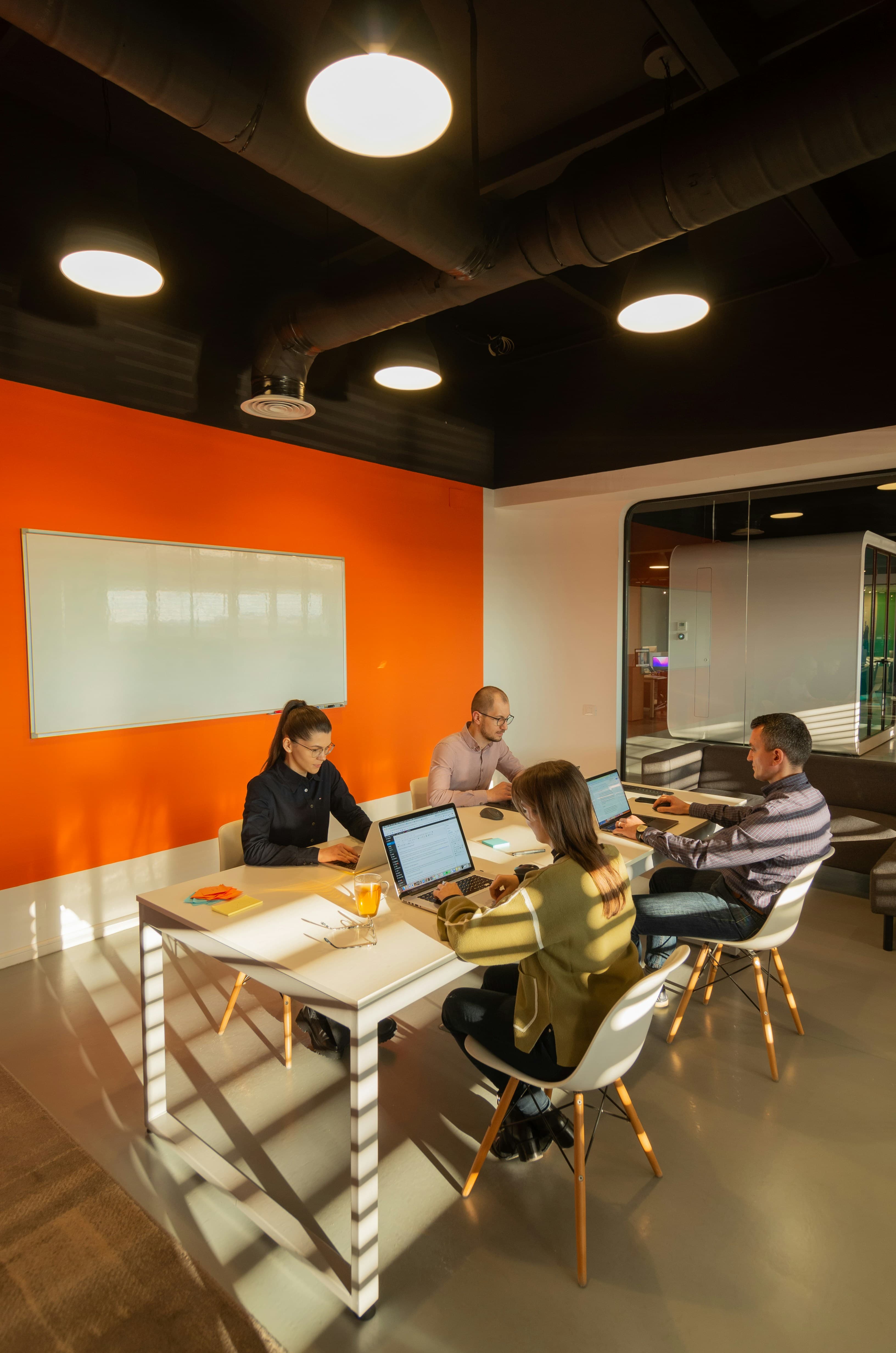 The Quatro Consulting team collaborating on laptops in a modern office